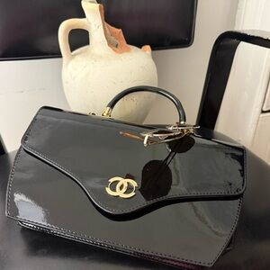 Black Patent Leather Handbag with a fold over flap gold hardware handle cc logo